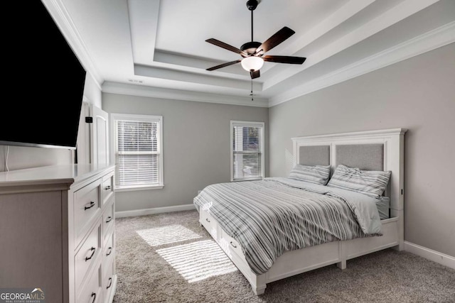 carpeted bedroom featuring crown molding, ceiling fan, and a raised ceiling