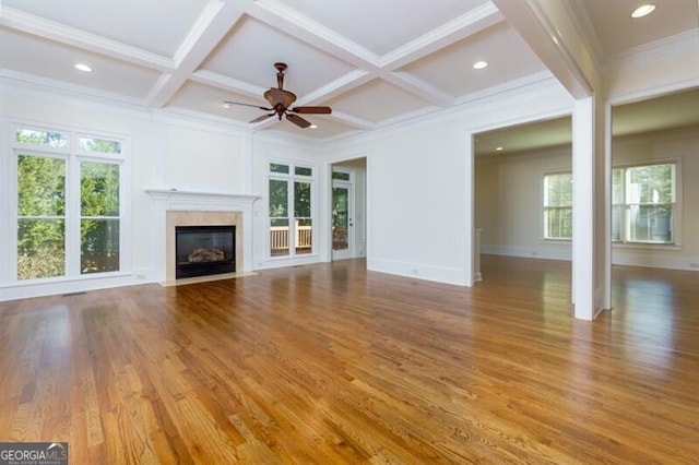 unfurnished living room with ceiling fan, coffered ceiling, ornamental molding, light hardwood / wood-style floors, and beamed ceiling