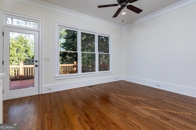 empty room with dark hardwood / wood-style flooring, ornamental molding, and ceiling fan