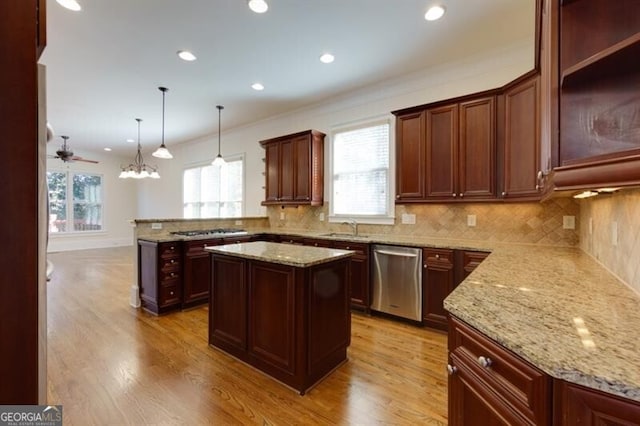 kitchen with sink, hanging light fixtures, stainless steel appliances, a center island, and kitchen peninsula