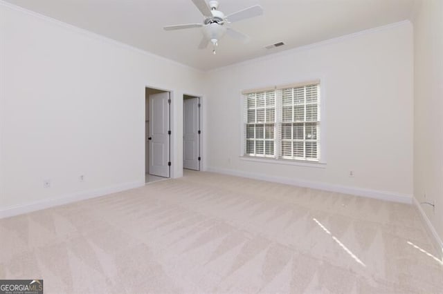 unfurnished room featuring light carpet, crown molding, and ceiling fan