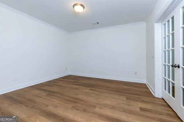 spare room with ornamental molding, hardwood / wood-style floors, and french doors