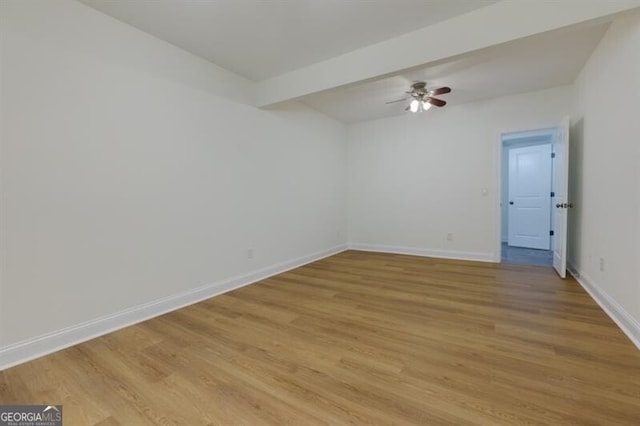 unfurnished room with beamed ceiling, ceiling fan, and light wood-type flooring