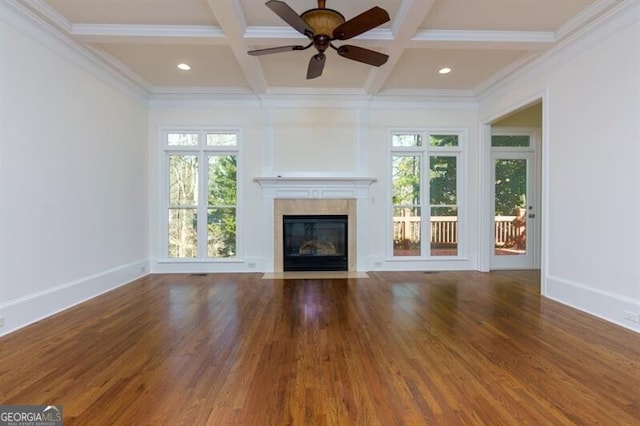 unfurnished living room featuring coffered ceiling, a healthy amount of sunlight, and dark wood-type flooring