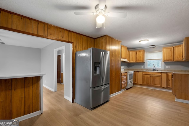 kitchen featuring sink, white electric range oven, stainless steel refrigerator with ice dispenser, a textured ceiling, and light hardwood / wood-style flooring