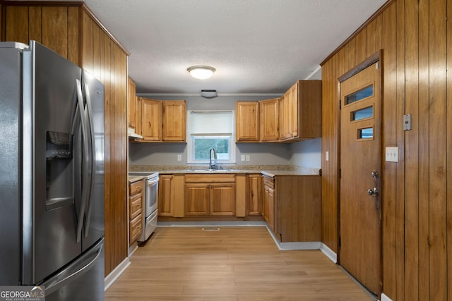 kitchen with white electric stove, sink, stainless steel refrigerator with ice dispenser, a textured ceiling, and light hardwood / wood-style flooring