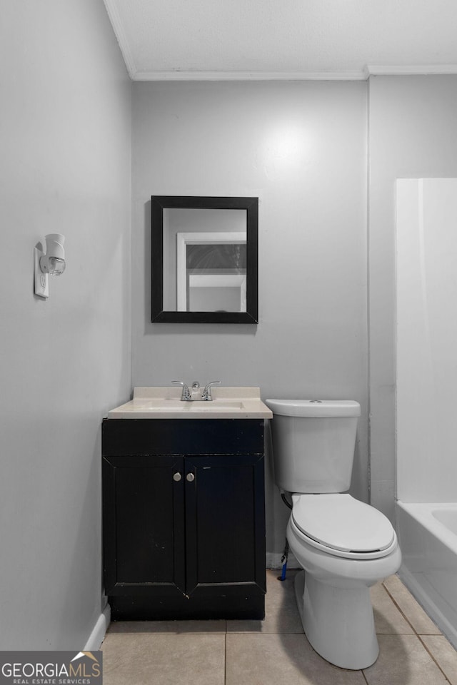 bathroom featuring vanity, a washtub, tile patterned floors, and toilet