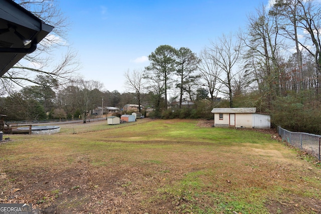 view of yard with a pool and a storage shed