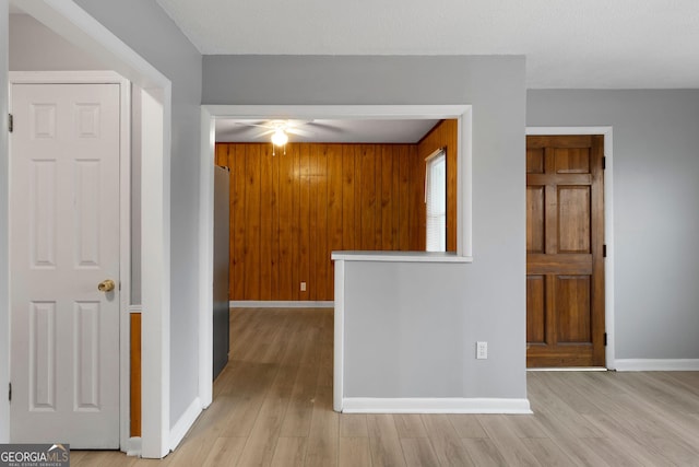 empty room with wooden walls and light hardwood / wood-style floors