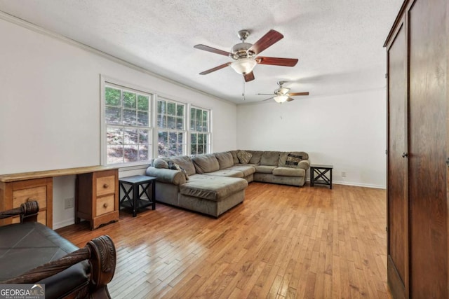 living room with ceiling fan, built in desk, a textured ceiling, and light wood-type flooring