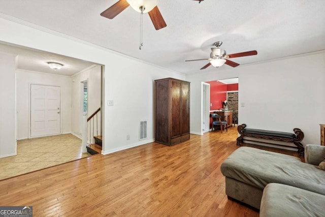 living room featuring crown molding, hardwood / wood-style floors, a textured ceiling, and ceiling fan