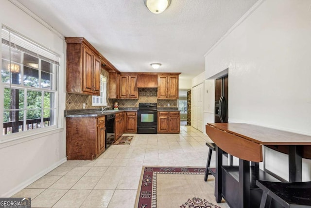 kitchen featuring light tile patterned floors, crown molding, sink, black appliances, and decorative backsplash