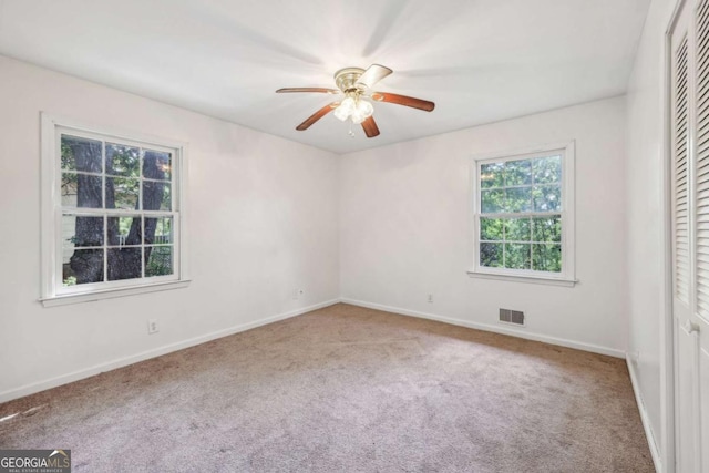 carpeted spare room featuring ceiling fan