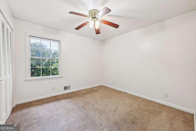 carpeted spare room featuring ceiling fan