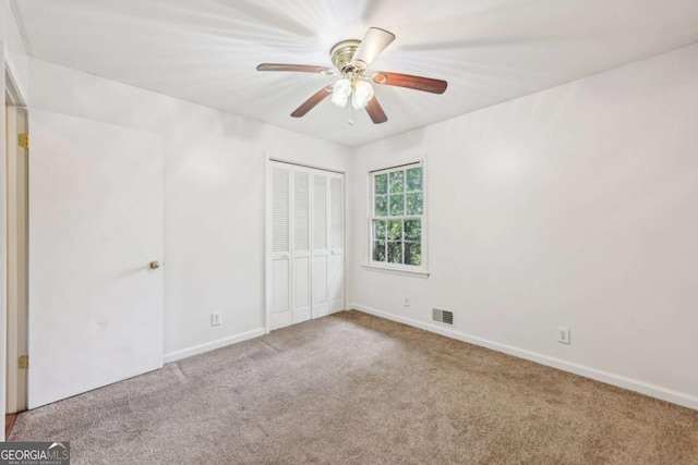 unfurnished bedroom featuring carpet floors, ceiling fan, and a closet