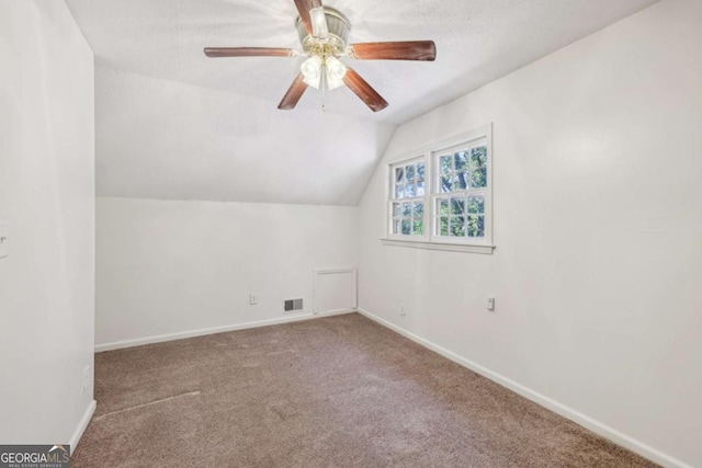 bonus room with lofted ceiling, a textured ceiling, ceiling fan, and carpet flooring