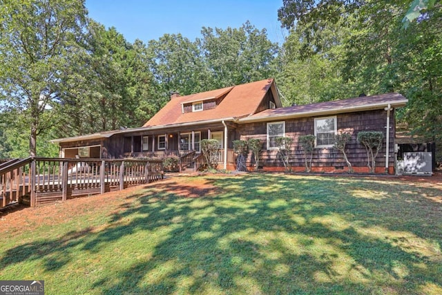 view of front of house featuring a wooden deck and a front lawn