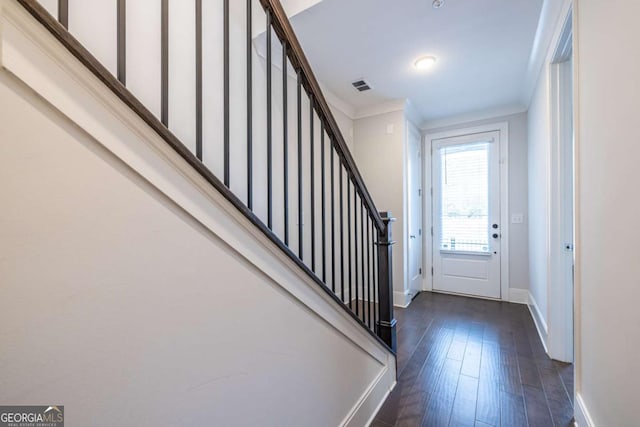 entryway with dark wood-style flooring, visible vents, baseboards, and stairs