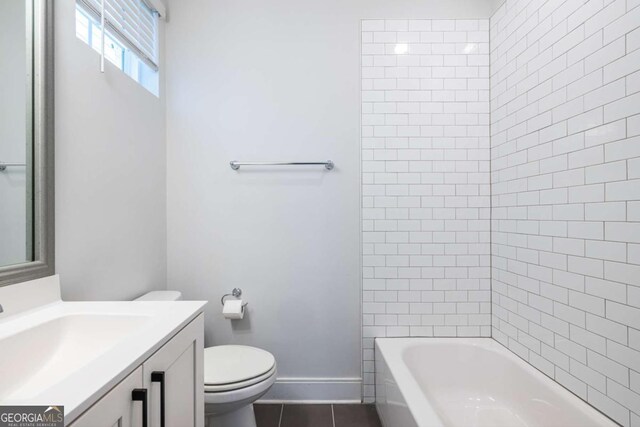 full bathroom featuring vanity, tiled shower / bath combo, tile patterned floors, and toilet