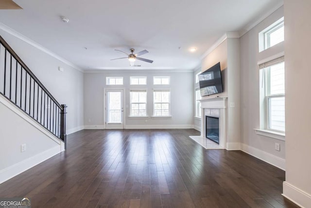 unfurnished living room featuring a fireplace with flush hearth, dark wood finished floors, baseboards, and stairs