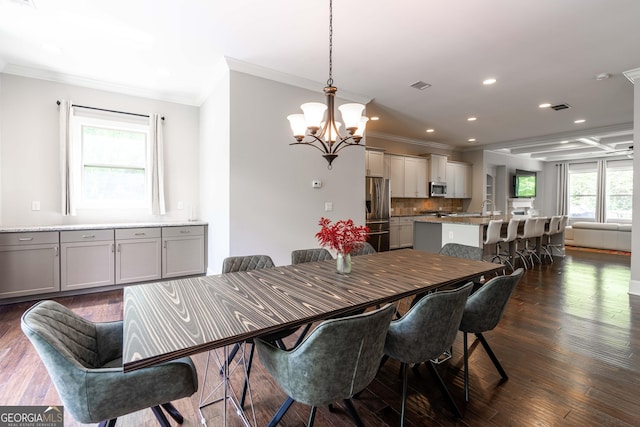 dining room with ornamental molding, dark hardwood / wood-style flooring, sink, and a notable chandelier