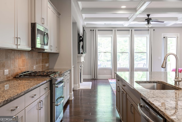 kitchen with white cabinetry, sink, stainless steel appliances, and light stone countertops