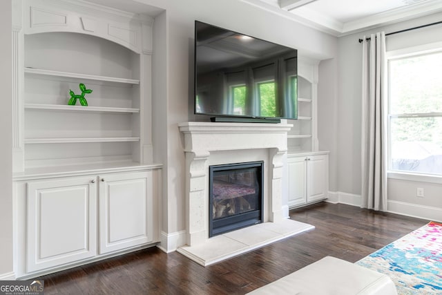 living room featuring dark hardwood / wood-style flooring, ornamental molding, and built in features