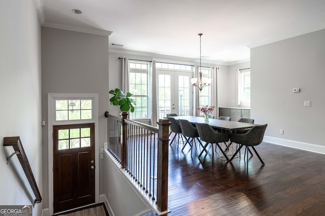 dining space with ornamental molding, an inviting chandelier, dark hardwood / wood-style flooring, and french doors