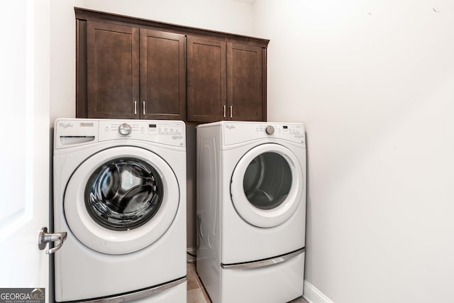 laundry room featuring cabinets and washing machine and clothes dryer