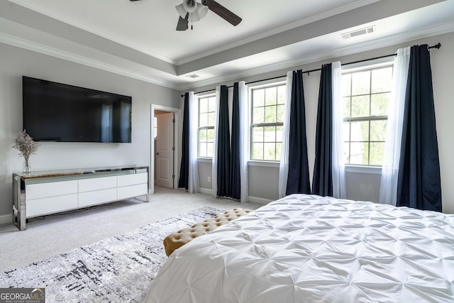 bedroom with crown molding, a raised ceiling, light carpet, and multiple windows