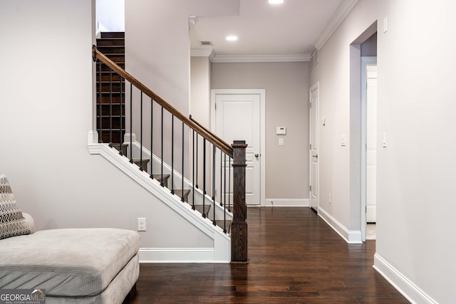 entryway with ornamental molding and dark hardwood / wood-style floors