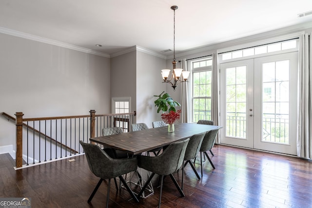 dining area featuring dark wood-type flooring, crown molding, french doors, and a notable chandelier