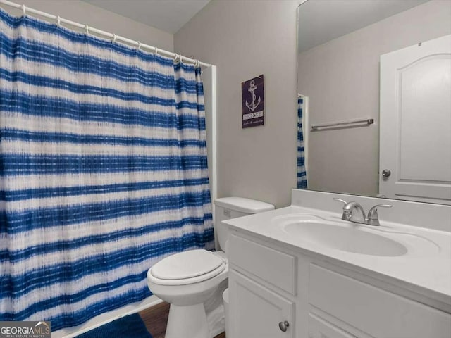 bathroom featuring hardwood / wood-style flooring, vanity, walk in shower, and toilet