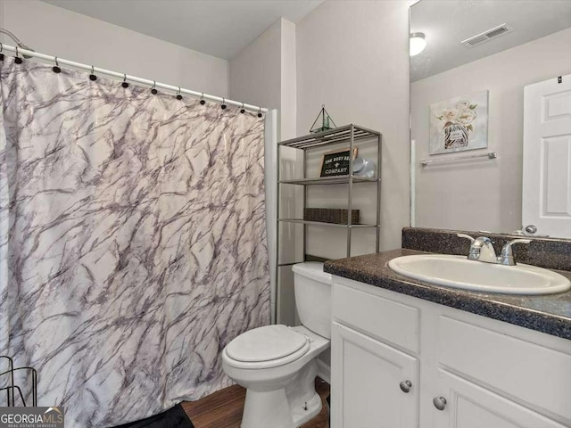 bathroom with a shower with curtain, vanity, hardwood / wood-style floors, and toilet