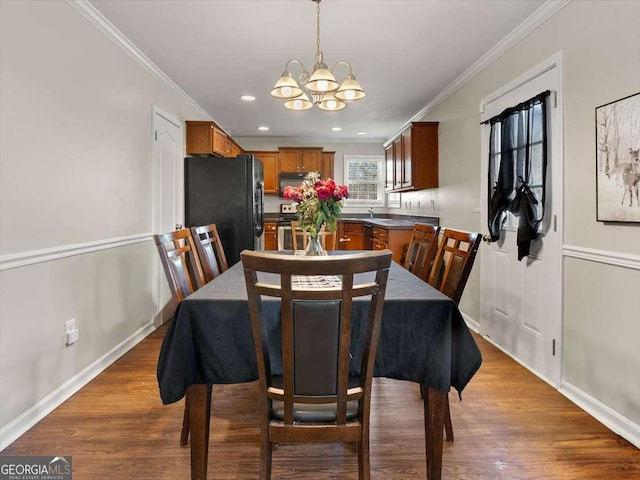 dining area with crown molding, wood-type flooring, and a chandelier