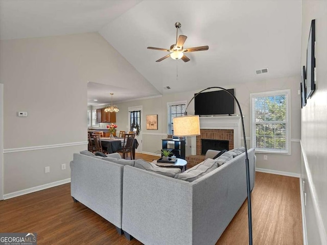 living room featuring ceiling fan, high vaulted ceiling, a fireplace, and dark hardwood / wood-style flooring