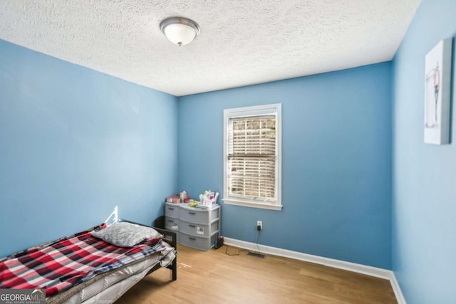 bedroom featuring a textured ceiling and light wood-type flooring