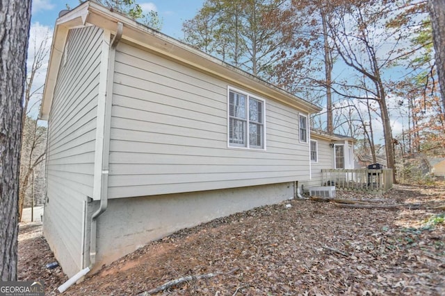 view of property exterior featuring central air condition unit and a deck