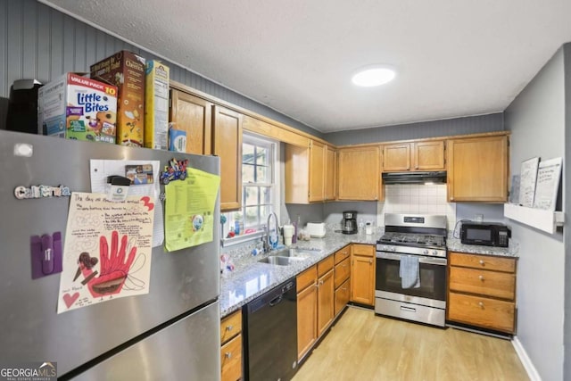 kitchen with light stone counters, sink, light hardwood / wood-style flooring, and black appliances