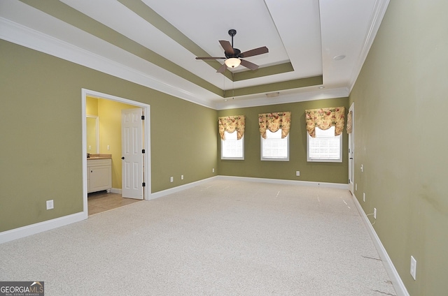 carpeted empty room with ornamental molding, a raised ceiling, and ceiling fan