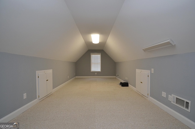 bonus room featuring lofted ceiling and light carpet