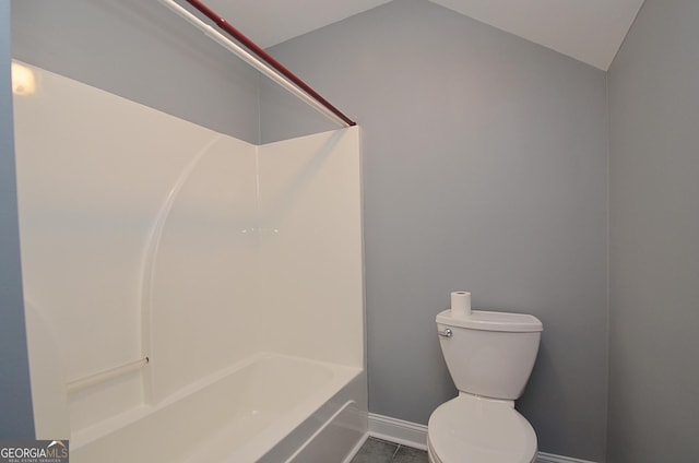 bathroom with tile patterned flooring, vaulted ceiling, and toilet