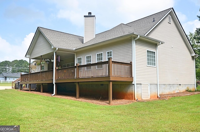 rear view of property featuring a lawn and a deck