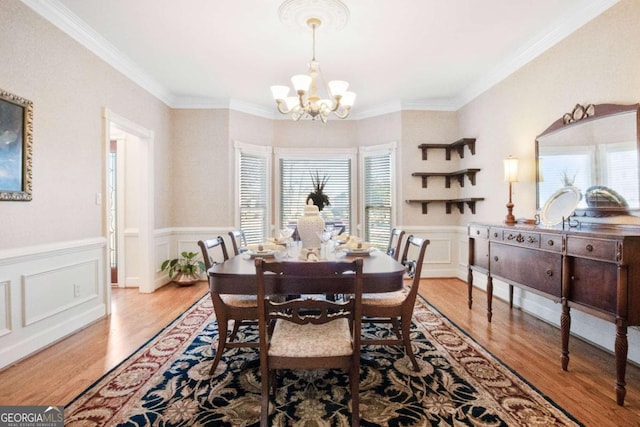 dining room featuring crown molding, light hardwood / wood-style floors, and a chandelier