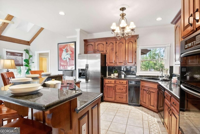 kitchen with sink, hanging light fixtures, black appliances, a kitchen island, and decorative backsplash