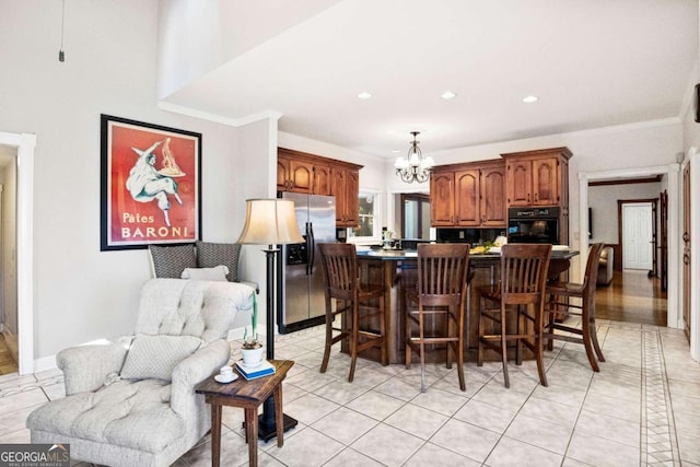 dining space with ornamental molding, light tile patterned floors, and a notable chandelier