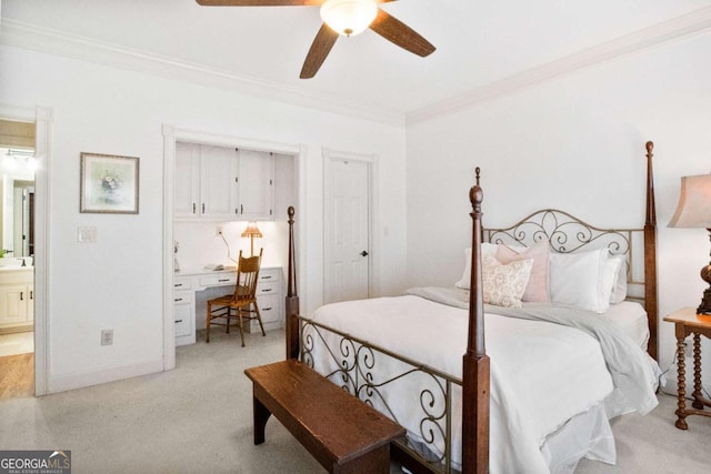 carpeted bedroom with crown molding, built in desk, and ceiling fan