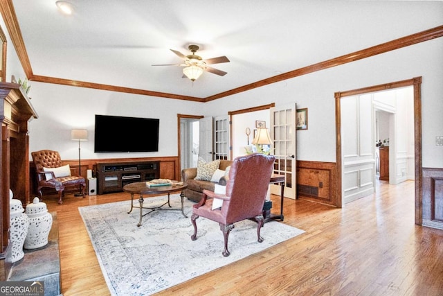 living room with crown molding, ceiling fan, and light hardwood / wood-style floors