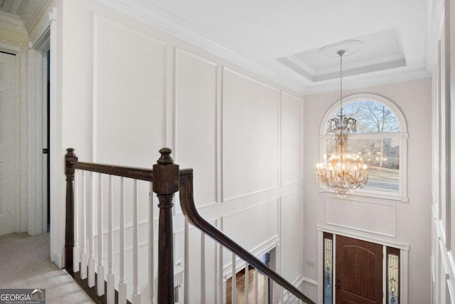 interior space featuring crown molding, a tray ceiling, and a notable chandelier