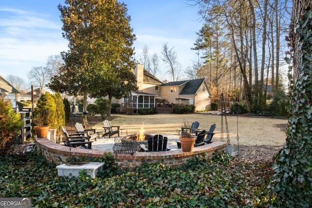 view of yard featuring a fire pit and a sunroom